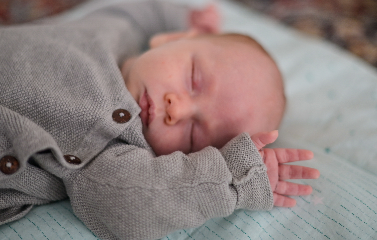 Baby, Neugeborenes liegt auf Decke